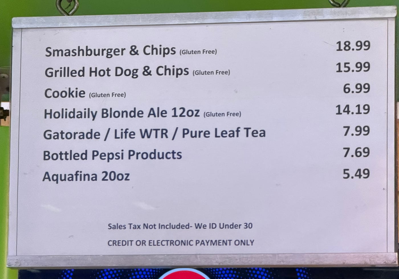 The menu board at No Gluten Way: gluten-free smashburger, hot dog, cookie, and a Holidaily blonde ale.